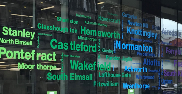 Front of Wakefield One with local place names on the windows