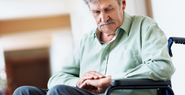 Man sat in wheelchair looking down at his hands