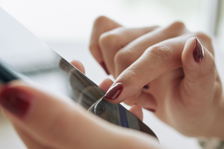 Photo of a close up of someone's hands using a mobile phone