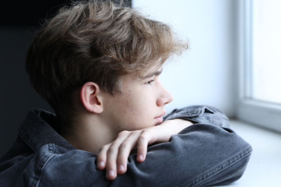 Young man looking out of a window