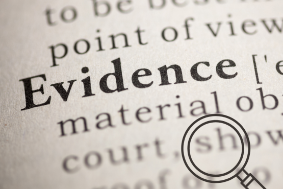 photo of a dictionary entry for 'evidence' with a small magnifying glass