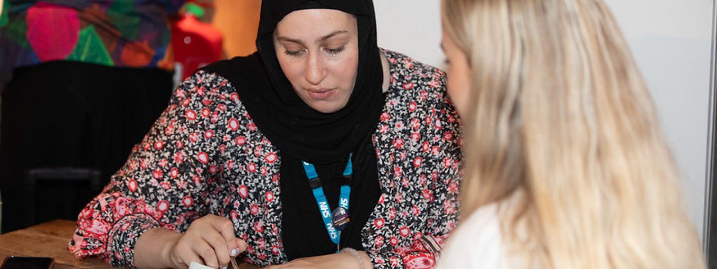 Two women talking over a blood pressure monitor
