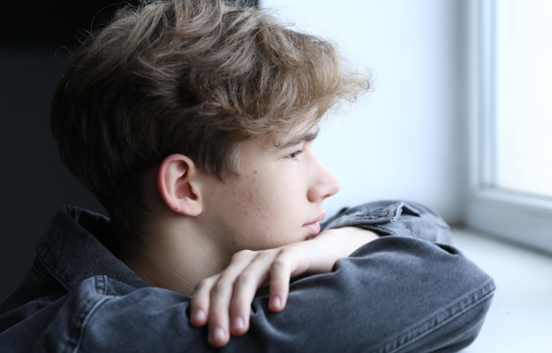 Young man looking out of a window